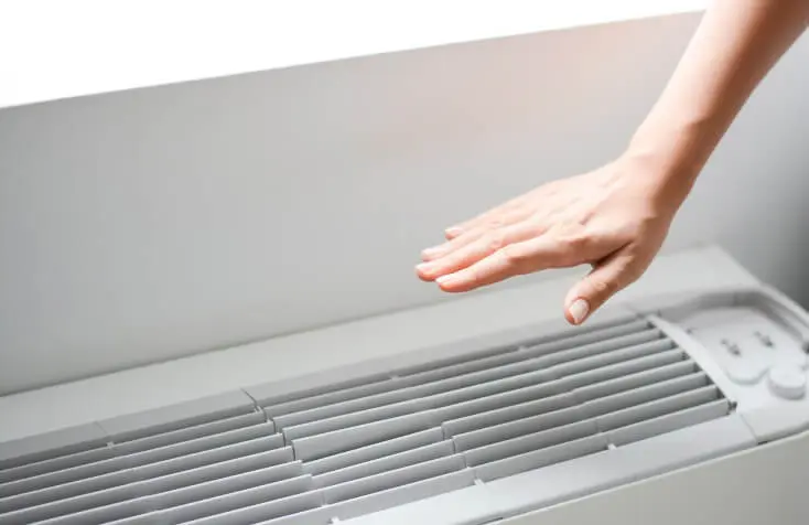 A hand feeling air cooling through an ac