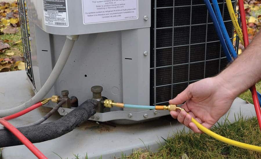 A person holding the pressure wire of an AC refrigerant