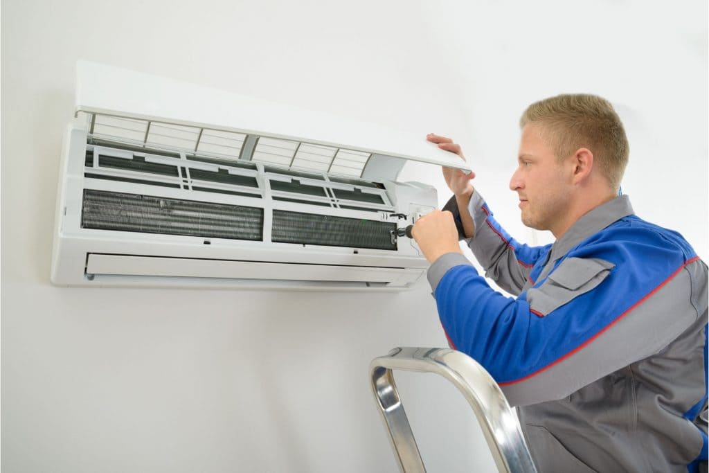 A person inspecting the inner AC unit