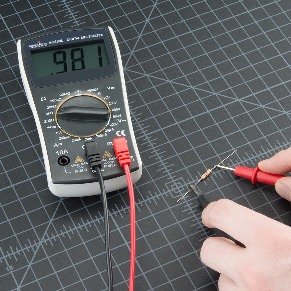 A person setting up a multimeter with tools