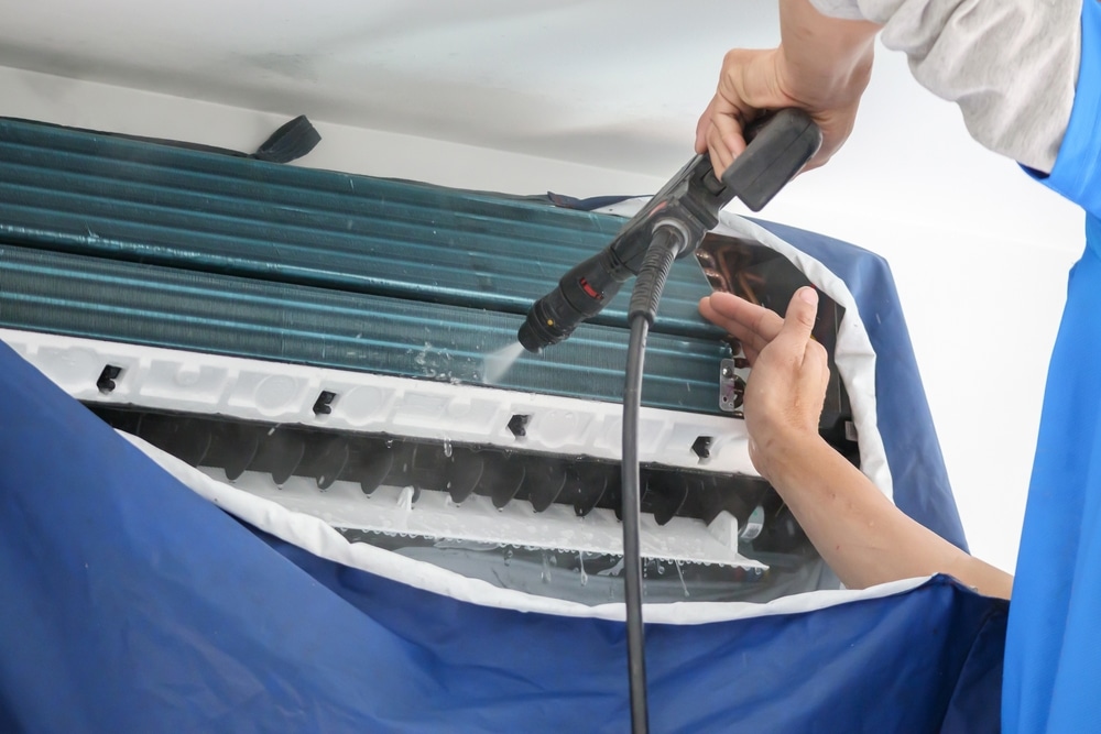 A view of a person cleaning an ac coil inside