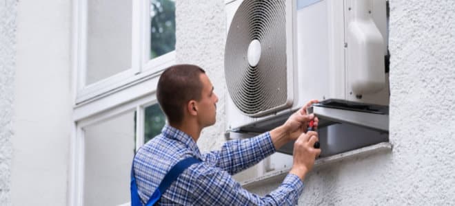 A view of a person installing ac in window outside