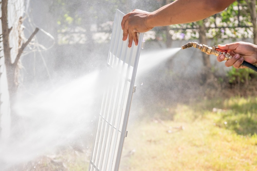 A view of a person washing ac filter with a water filter