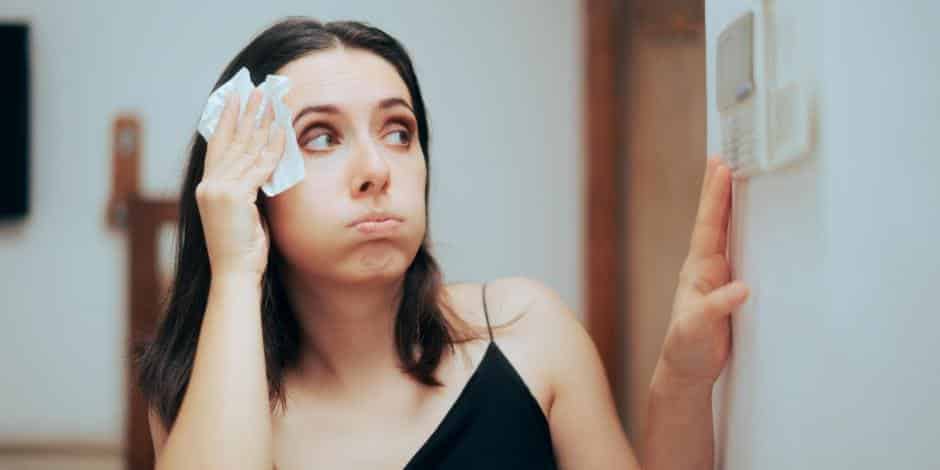 A view of a woman wiping off her sweat because of hot ac air