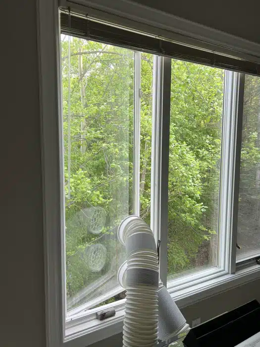 An AC pipe going out the casement window