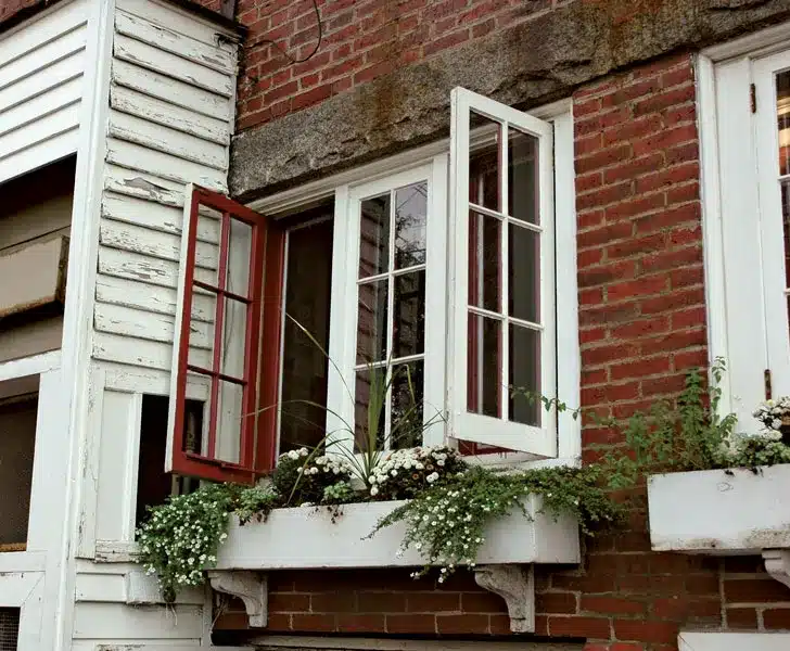 An outdoor view of an opened casement window in a house