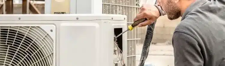 A view of a hvac technician working to fix an ac fan