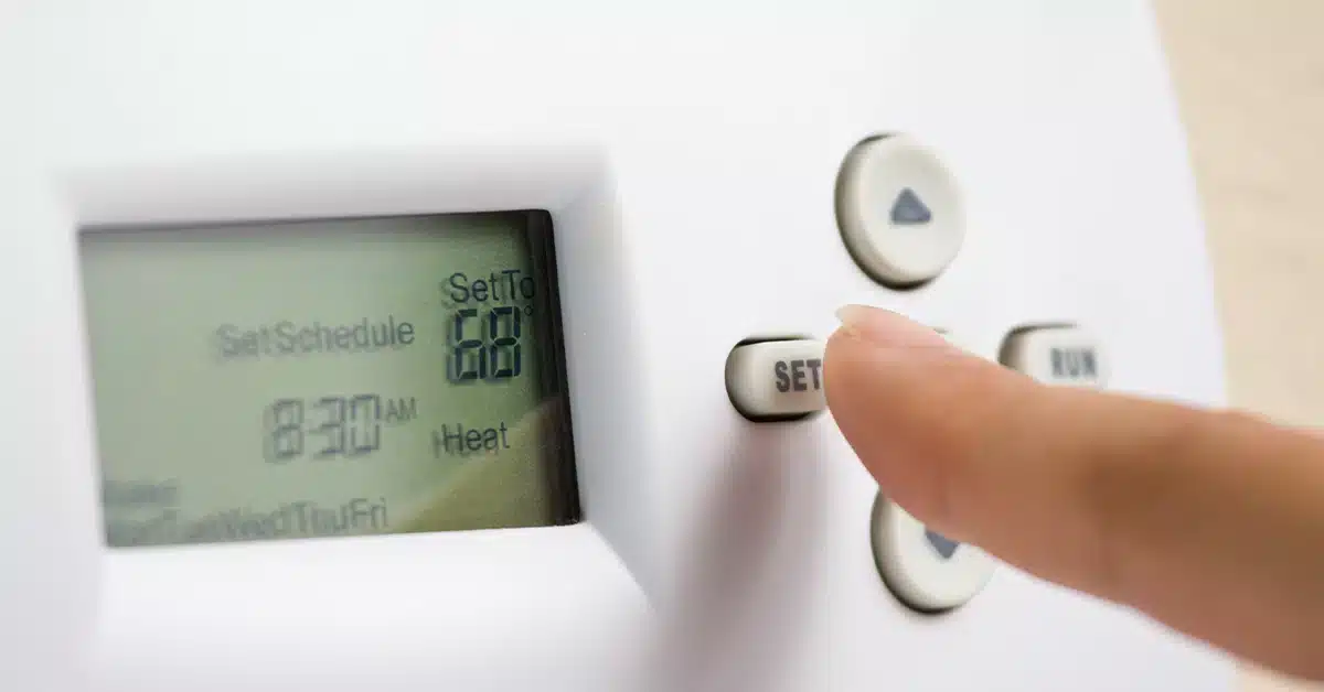 A view of a person setting the temperature on an ac thermostat