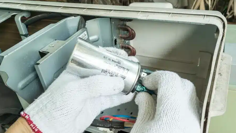 A view of a technician replacing an ac capacitor