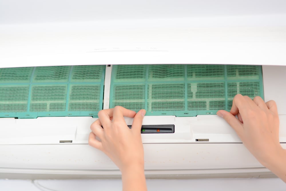 A view of two hands touching ac filter