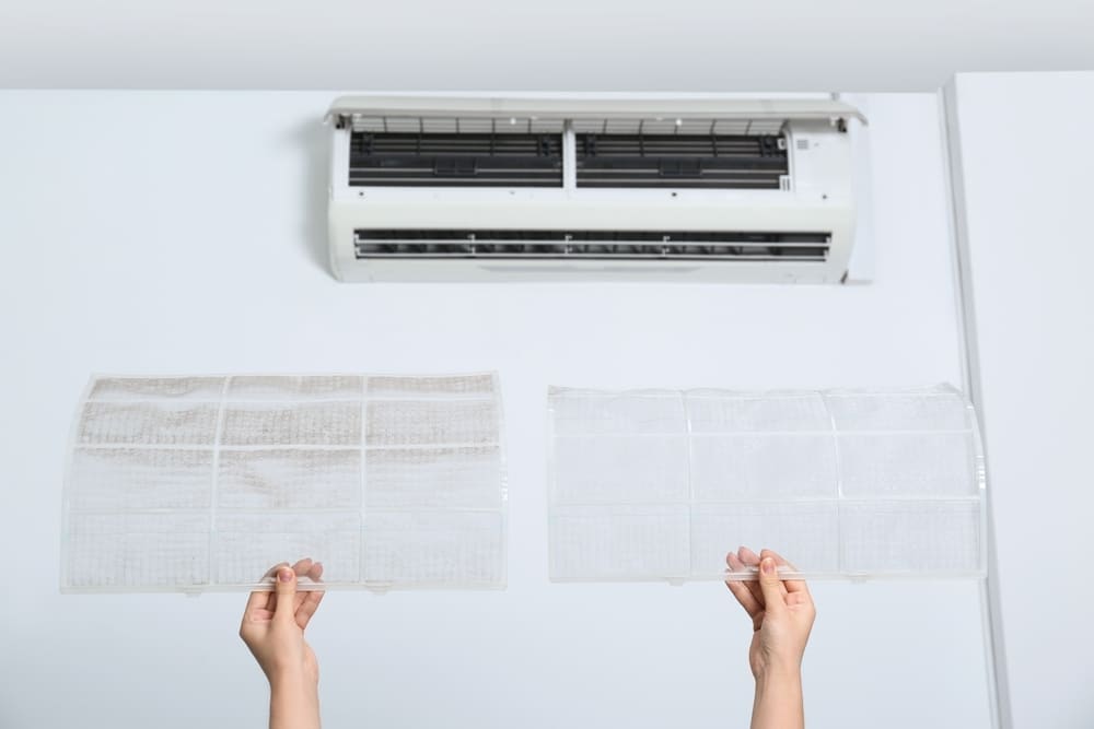 A view of a person holding ac filter with a front view of a split ac