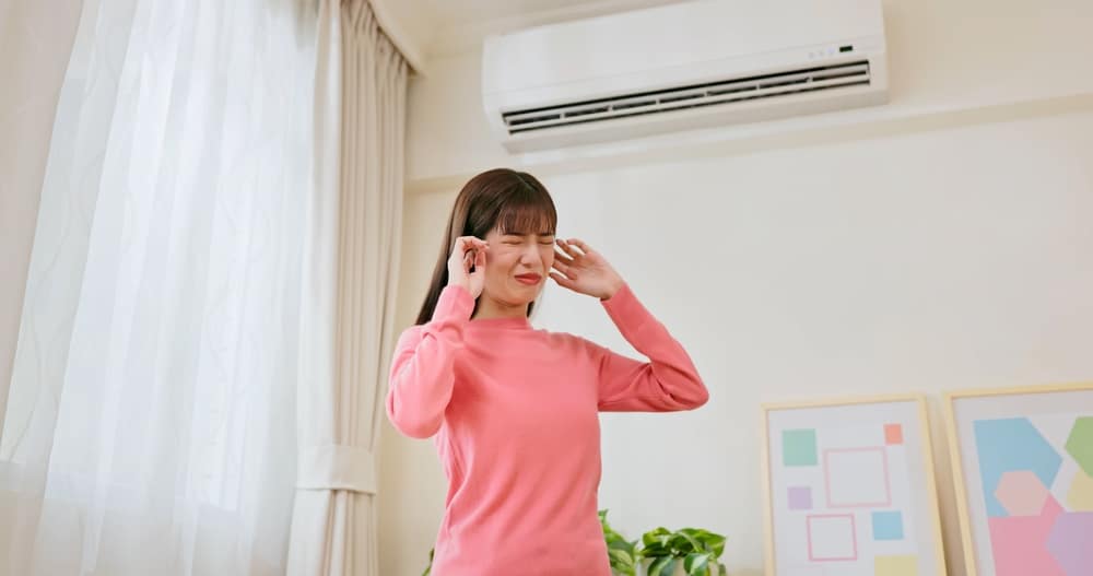 A view of a lady covering her ears from the ac noise